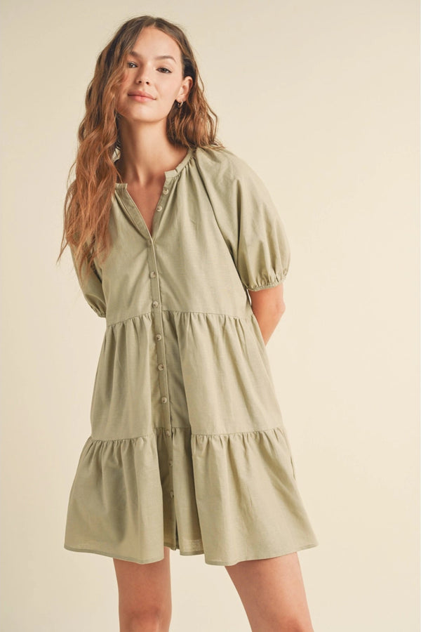 Woman wearing a light green dress against a beige background